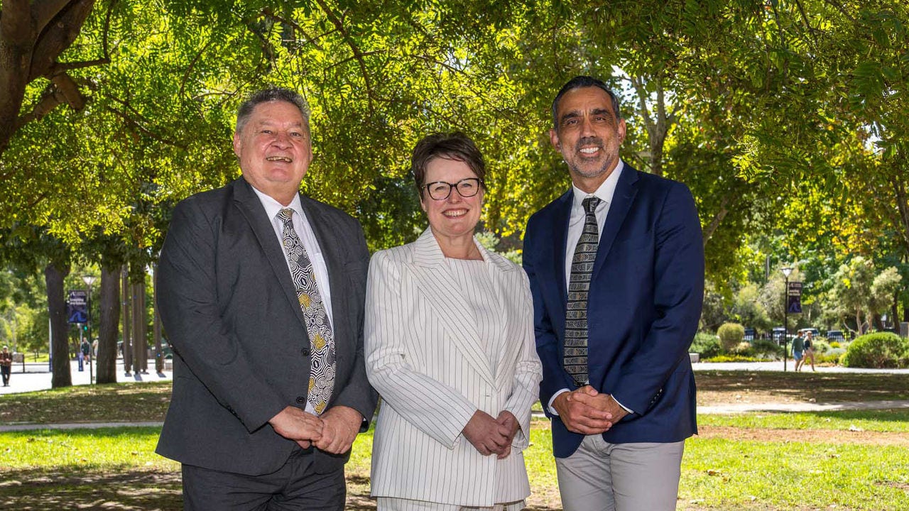Three people stand outside 