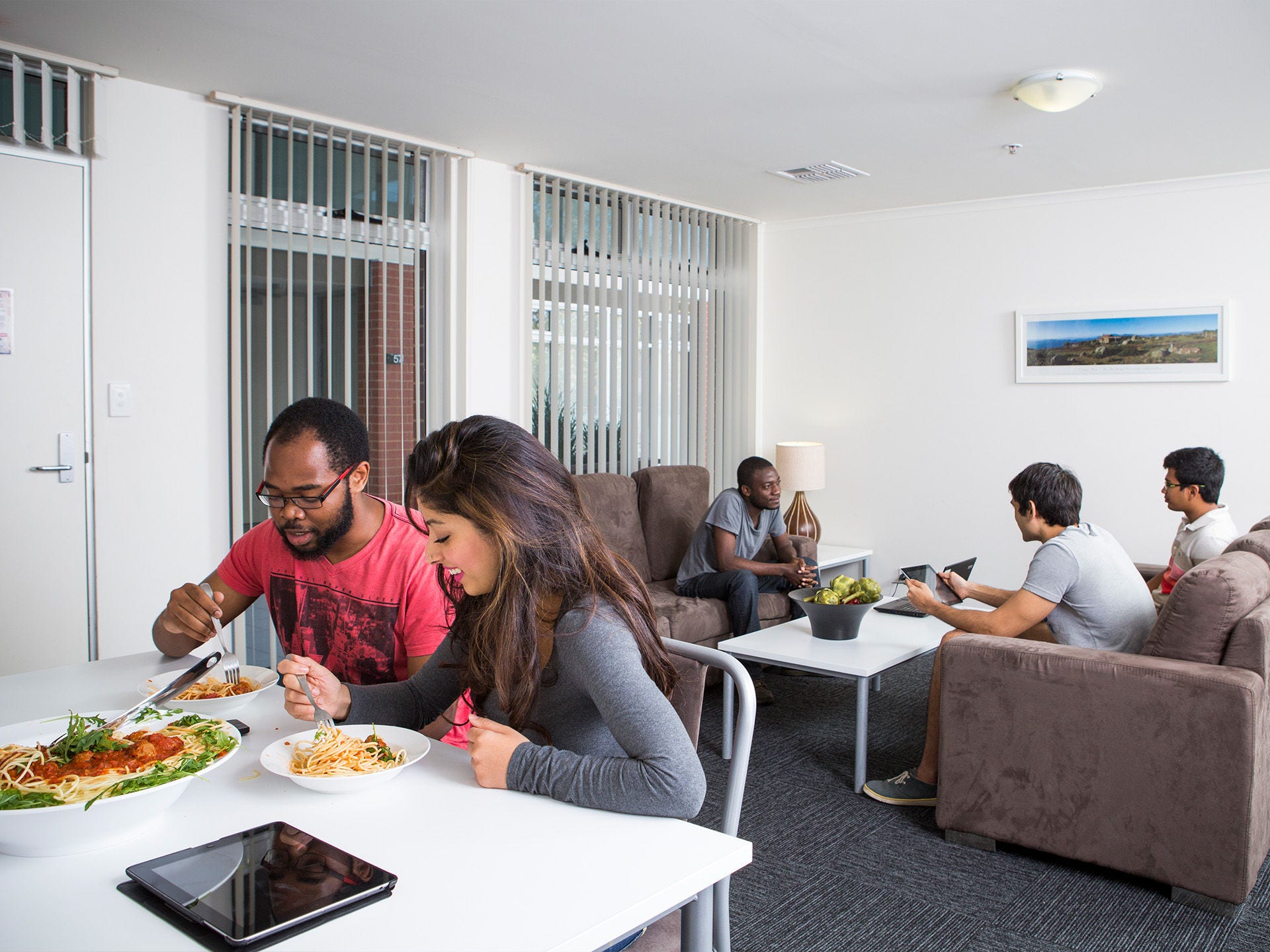 Residents using the common kitchen space at Adelaide University Village student accommodation