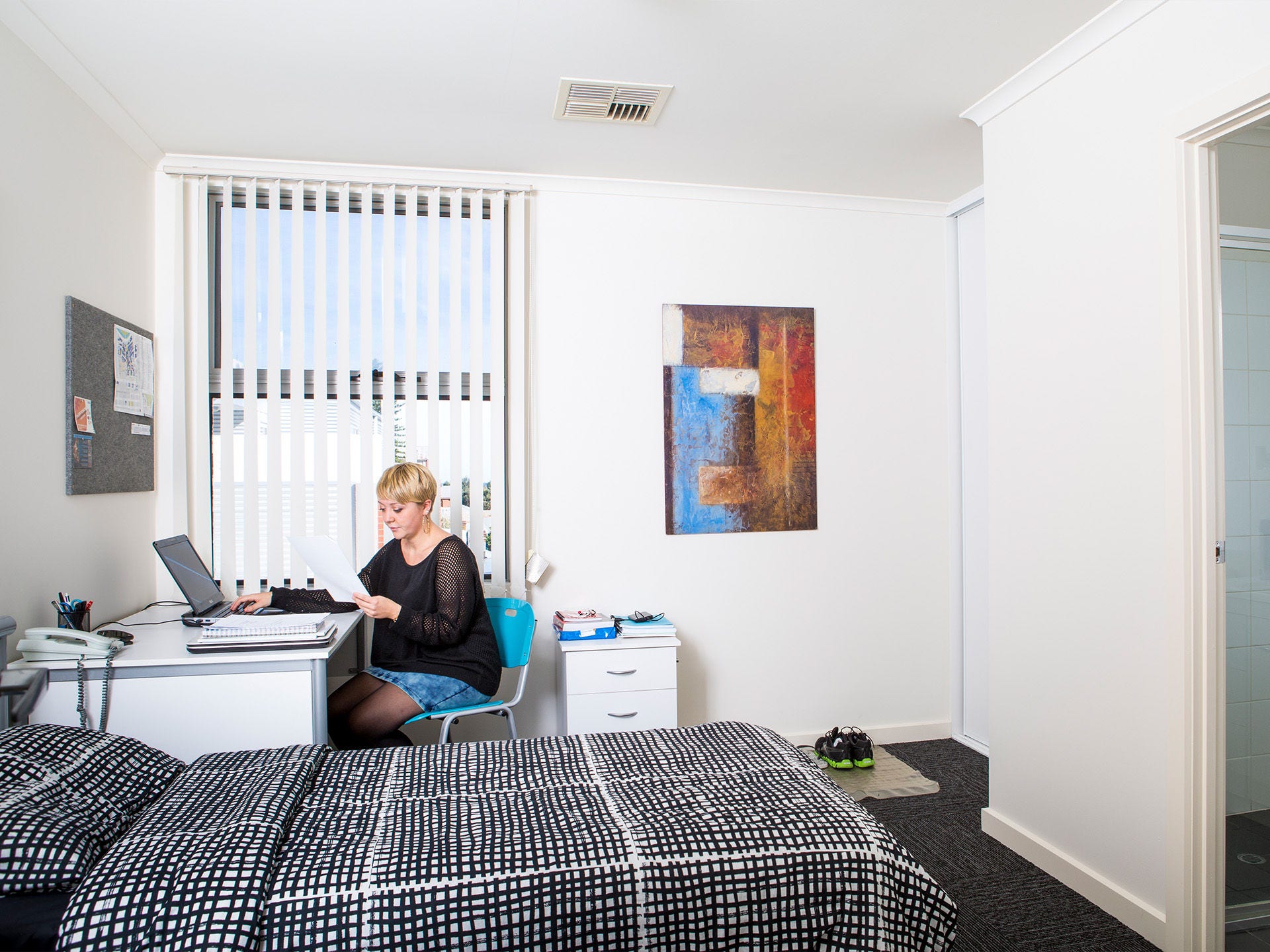 Resident in their bedroom at Adelaide University Village student accommodation
