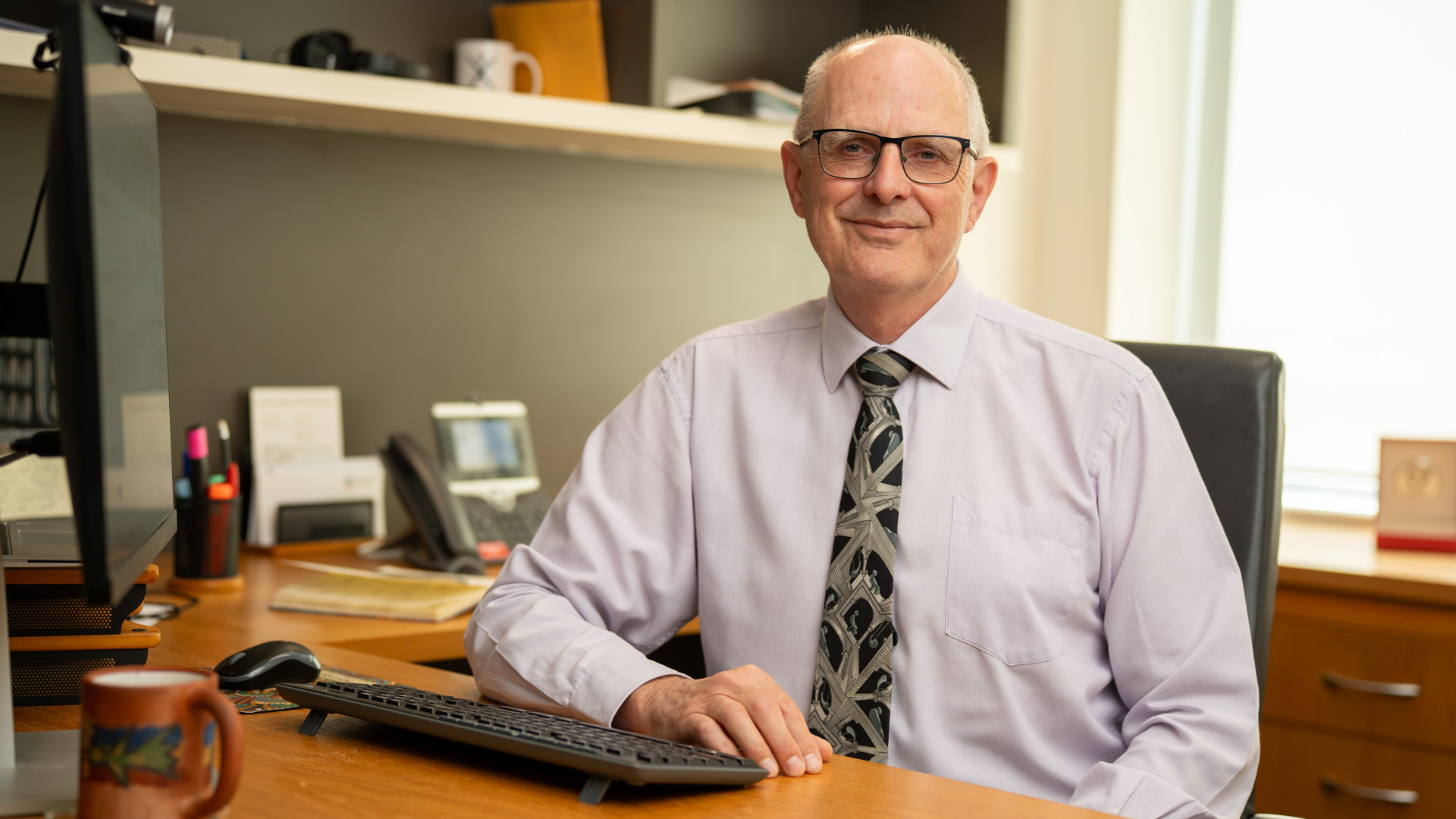 Professor Geoffrey Crisp sitting at a desk