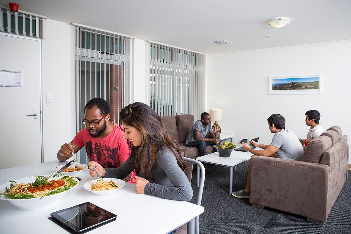 Residents using the common kitchen space at Adelaide University Village student accommodation