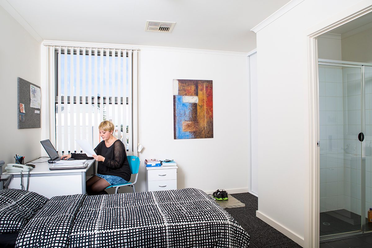 Resident in their bedroom at Adelaide University Village student accommodation